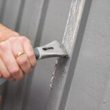 Skrapning av fasad med skrapa inför husmålning