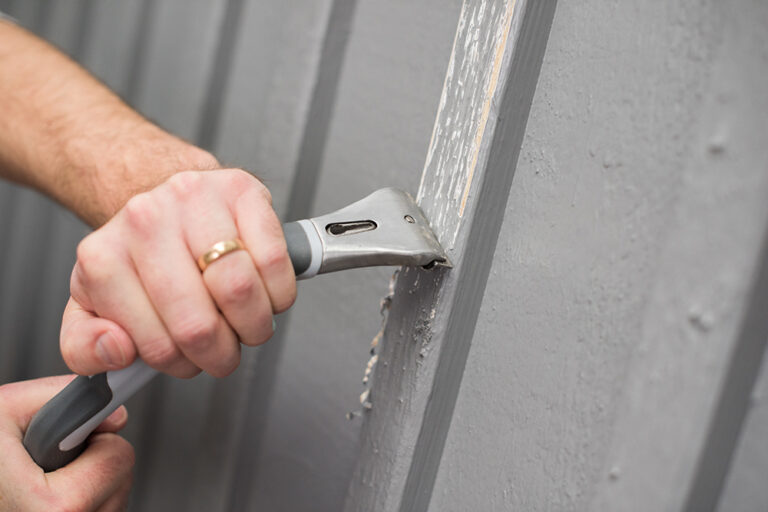 Skrapning av fasad med skrapa inför husmålning