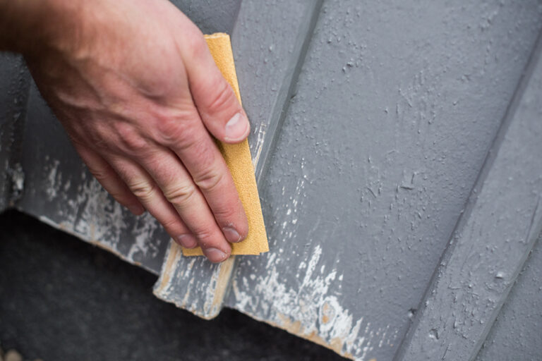 Slipning av fasad med sandpapper inför husmålning