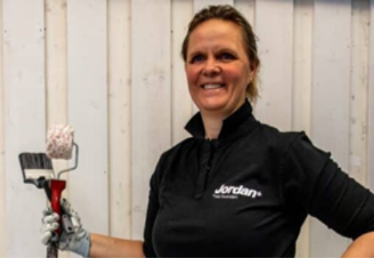 Kvinna som håller i måleriverktyg